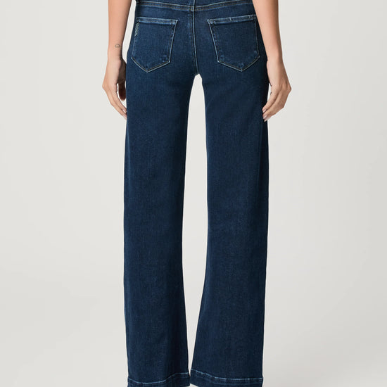 WOMAN WEARING BLUE JEANS ON WHITE BACKGROUND REAR VIEW