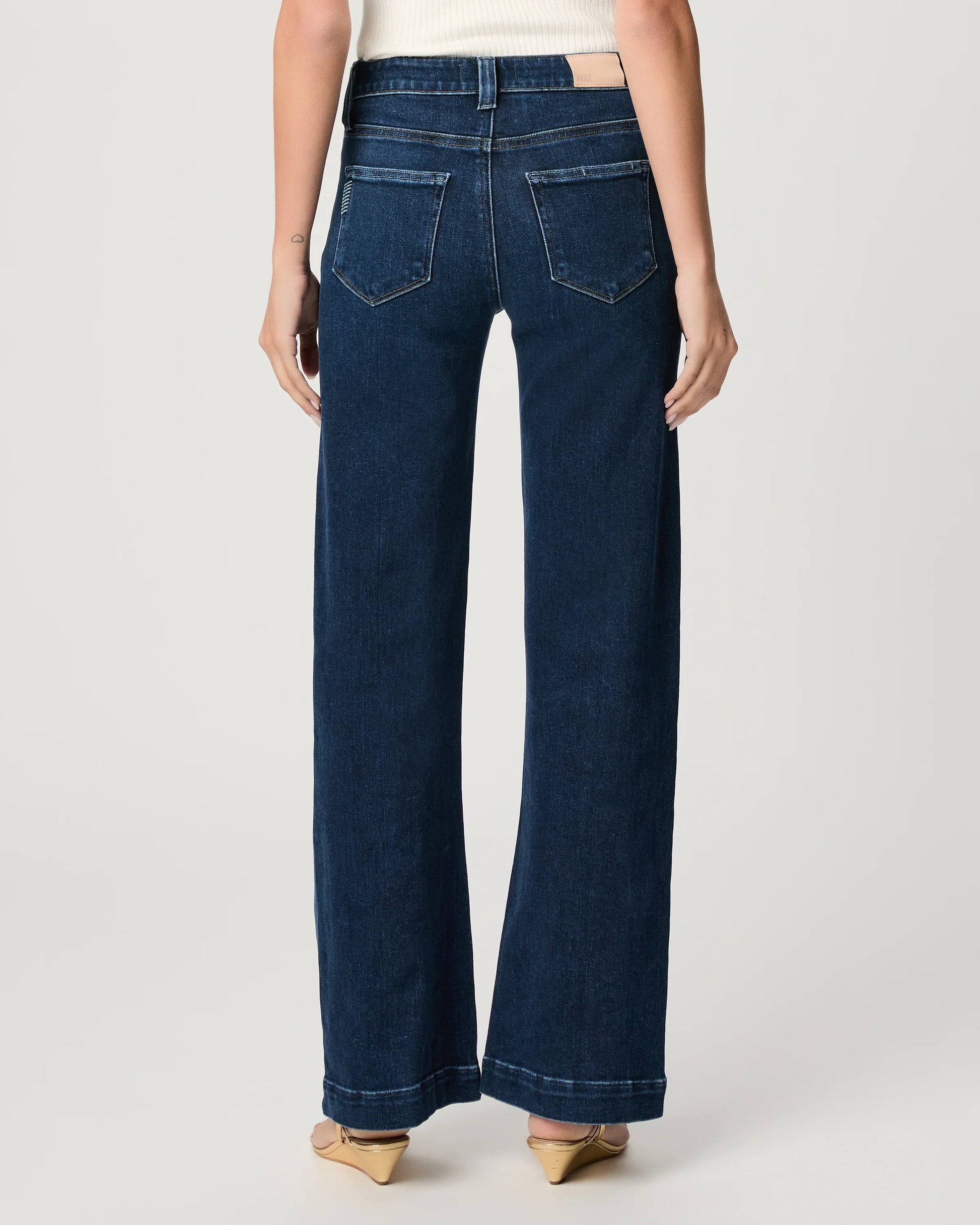WOMAN WEARING BLUE JEANS ON WHITE BACKGROUND REAR VIEW