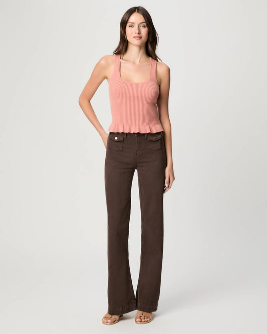 Woman wearing a pink sleeveless top and brown pants by Paige on a white background