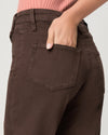 Brown pants with a pocket, worn by a person, on a plain background close up