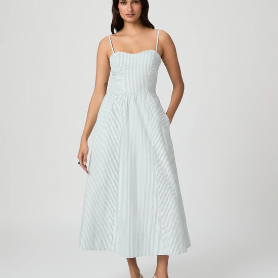 Woman wearing a light blue striped dress on a white background from Paige