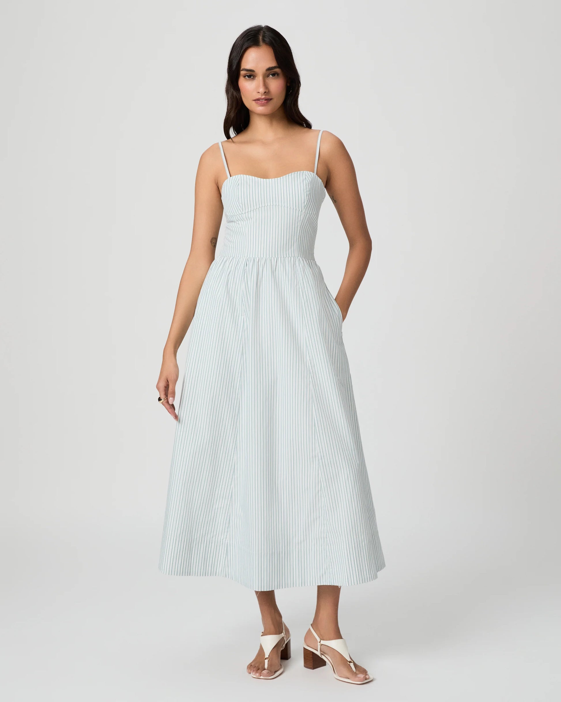 Woman wearing a light blue striped dress on a white background from Paige