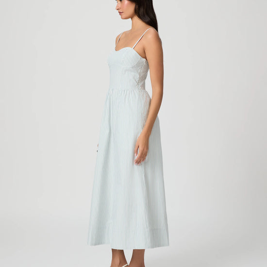 Woman wearing a light blue dress on a white background from Paige