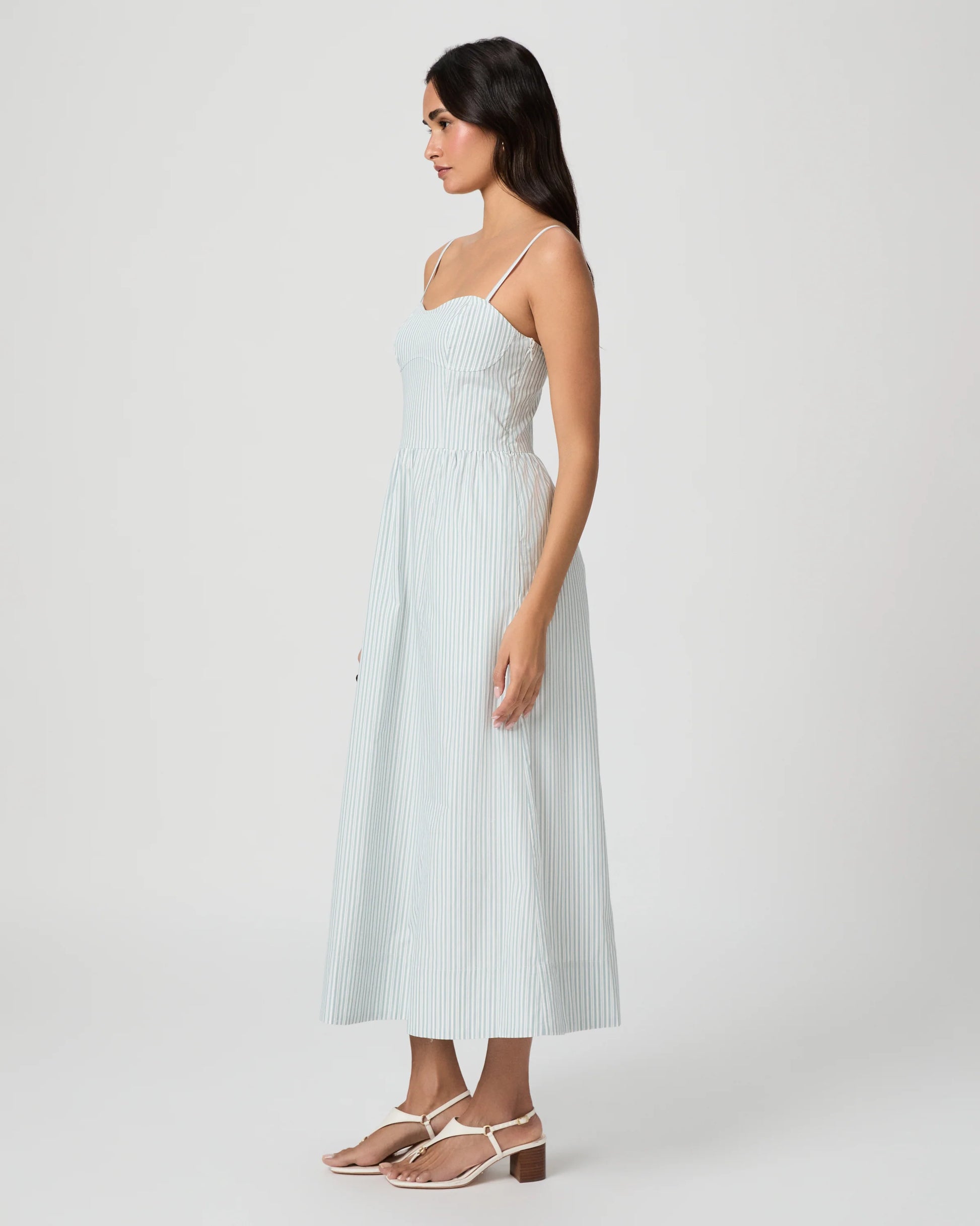 Woman wearing a light blue dress on a white background from Paige