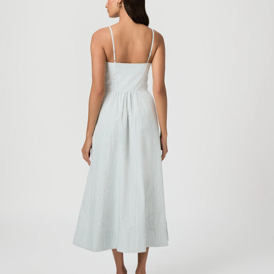 Woman wearing a light blue dress with thin straps on a white background from Paige
