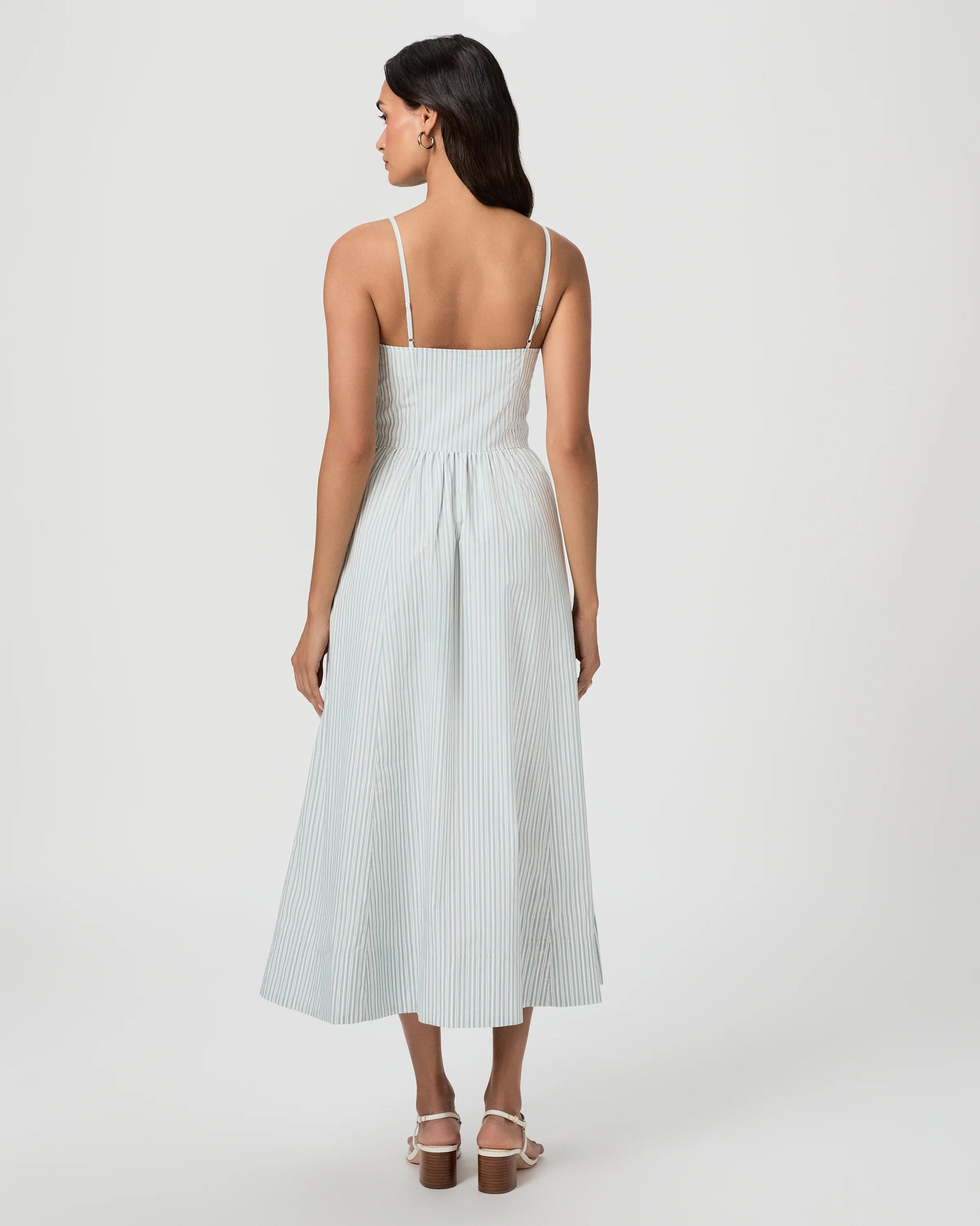 Woman wearing a light blue dress with thin straps on a white background from Paige