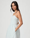 Woman wearing a light blue ribbed dress against a white background
