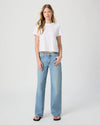 Woman wearing a white t-shirt and light blue jeans on a white background from Paige