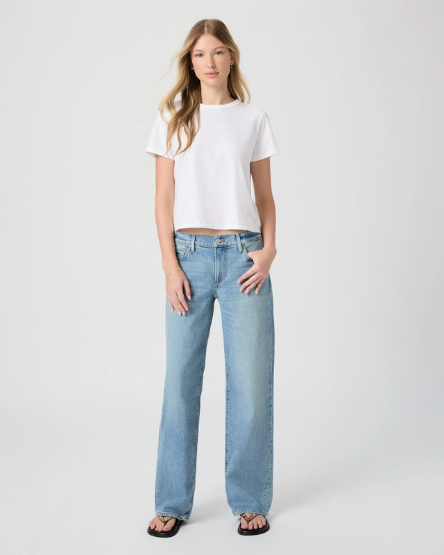 Woman wearing a white t-shirt and light blue jeans on a white background from Paige