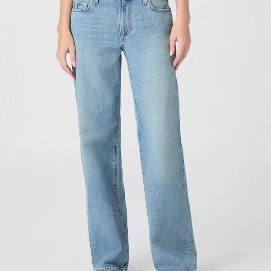 Light blue jeans worn by a person on a white background from Paige