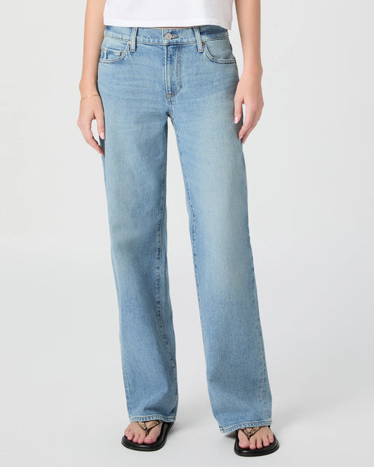 Light blue jeans worn by a person on a white background from Paige