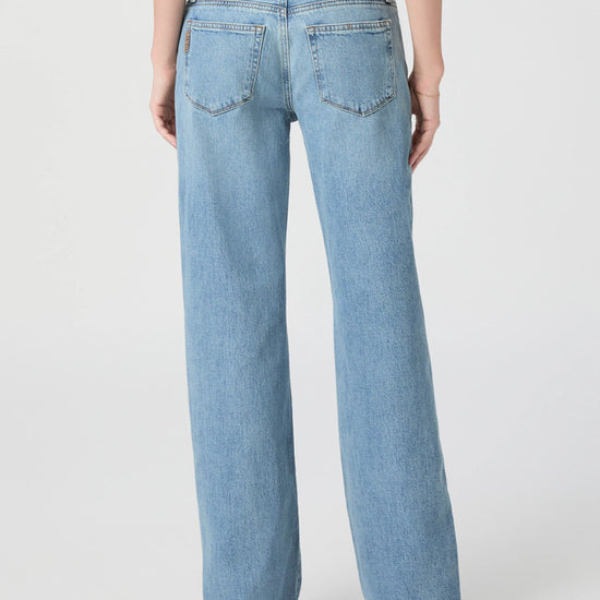Light blue jeans worn by a person on a white background from paige