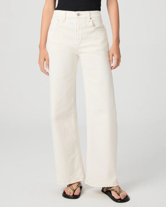Person wearing white Paige jeans on a plain background