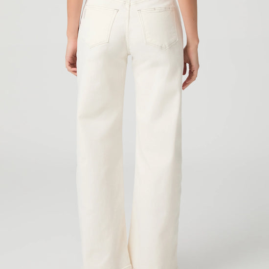 Person wearing white Paige jeans on a plain background rear view