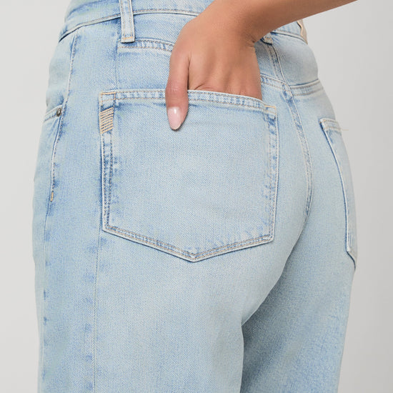 Light blue jeans worn by a person on a plain background