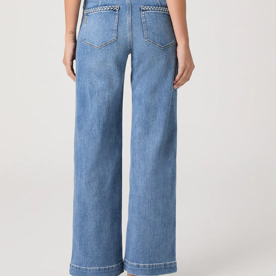 Person wearing blue wide-leg jeans on a white background