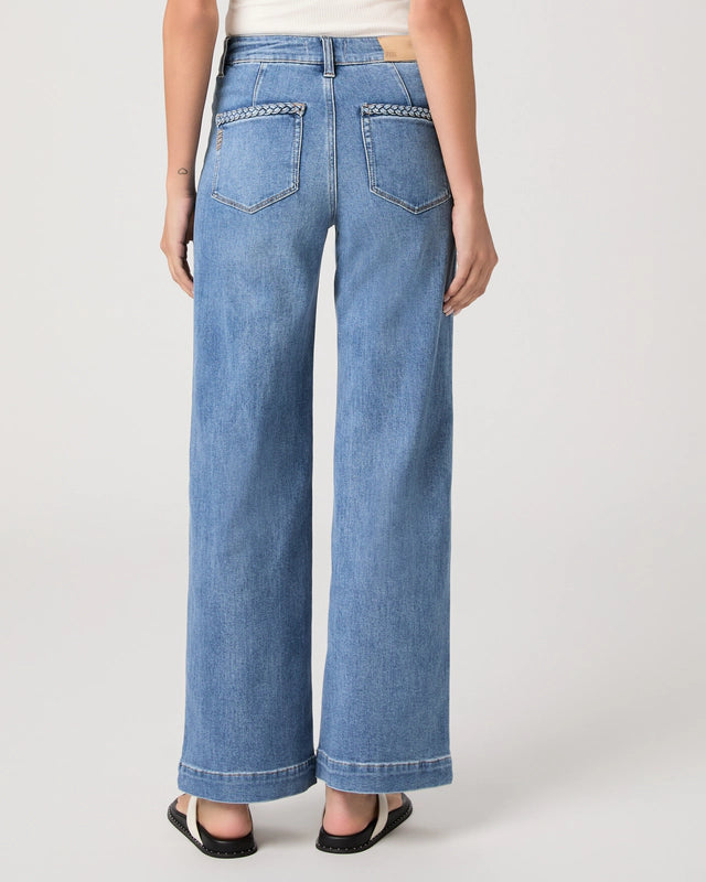 Person wearing blue wide-leg jeans on a white background