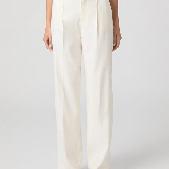 Person wearing white wide-leg pants on a plain background