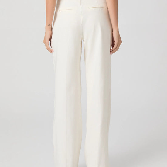 Person wearing white pants on a plain background
