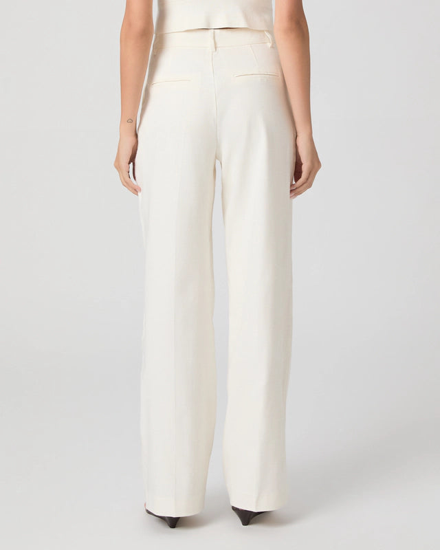 Person wearing white pants on a plain background