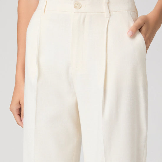 White pants worn by a person on a plain background
