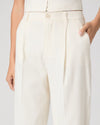 White pants worn by a person on a plain background