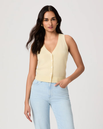 Woman wearing a light yellow sleeveless Paige top and light blue jeans on a plain background