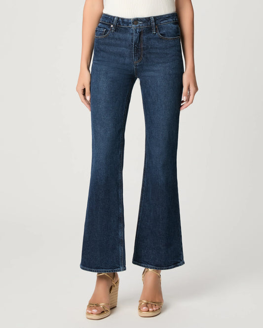Person wearing blue flared jeans on a white background