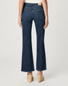 Person wearing dark blue flared jeans on a white background