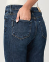 Close-up of blue jeans with a hand in the pocket on a light gray background