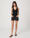 Woman wearing a black tank top and black shorts on a white background