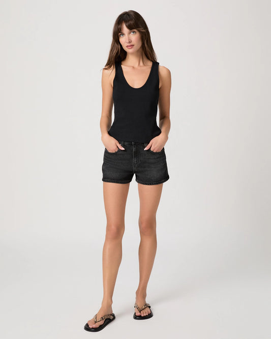 Woman wearing a black tank top and black shorts on a white background
