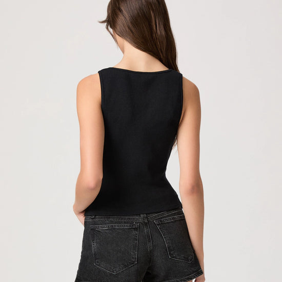 Person wearing a black sleeveless top and black shorts on a white background