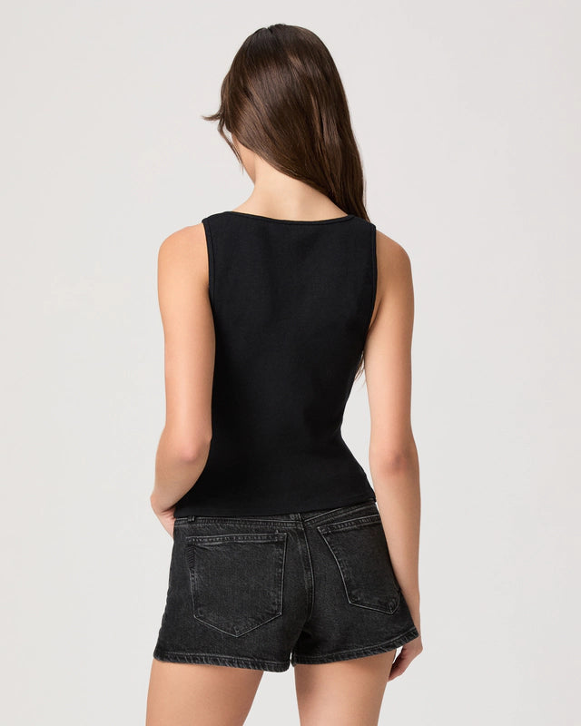 Person wearing a black sleeveless top and black shorts on a white background