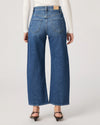 Person wearing blue jeans on a plain background