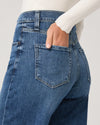 Close-up of blue jeans with a white sweater background