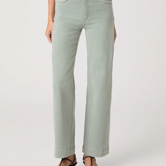 Light green jeans worn by a person on a white background
