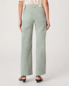 Person wearing light green wide-leg jeans on a white background