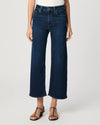 Person wearing dark blue wide-leg jeans on a white background