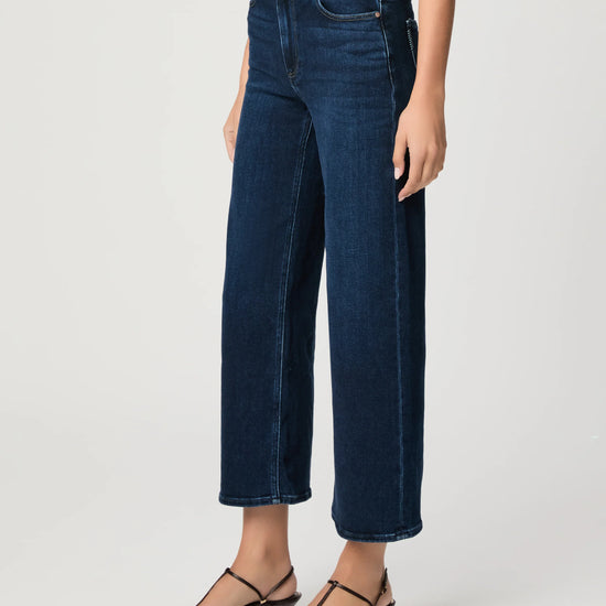 Person wearing dark blue jeans on a white background