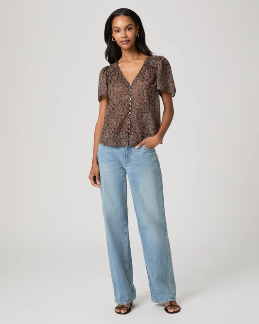 woman wearing a brown paisley blouse and jeans full outfit shot