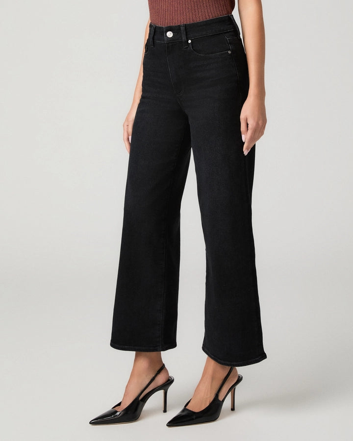 A model wearing black wide-leg cropped jeans with a ribbed top and black slingback heels, shown from the waist down against a light gray studio background.