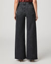 Rear view of a model wearing dark gray wide-leg denim jeans with a faded wash, paired with a dark red top and black heels, against a light gray studio background.