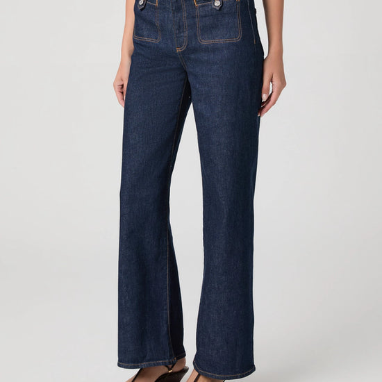 Dark blue jeans worn by a person on a white background