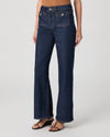 Dark blue jeans worn by a person on a white background