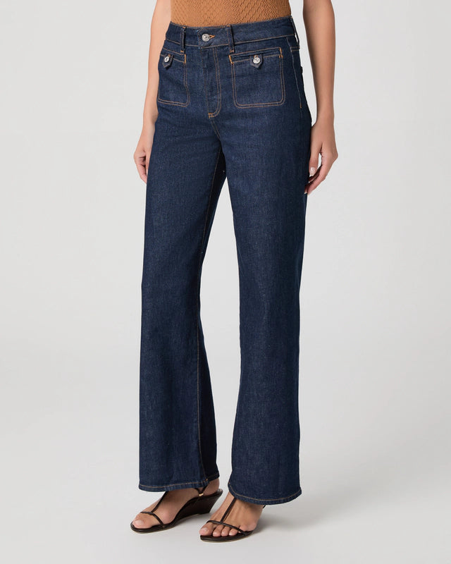 Dark blue jeans worn by a person on a white background