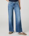 Model wearing blue jeans on a grey background