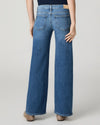 Model wearing blue jeans on a grey background rear view