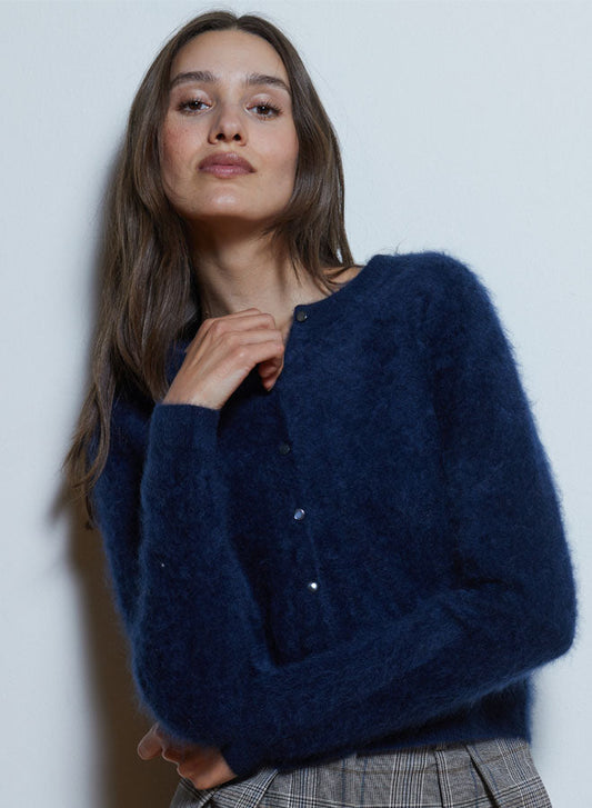 Woman wearing a navy blue cardigan against a plain background