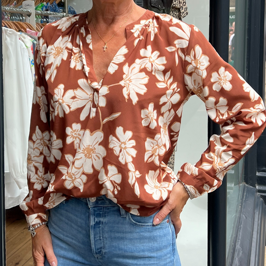 A tan top with white flowers 